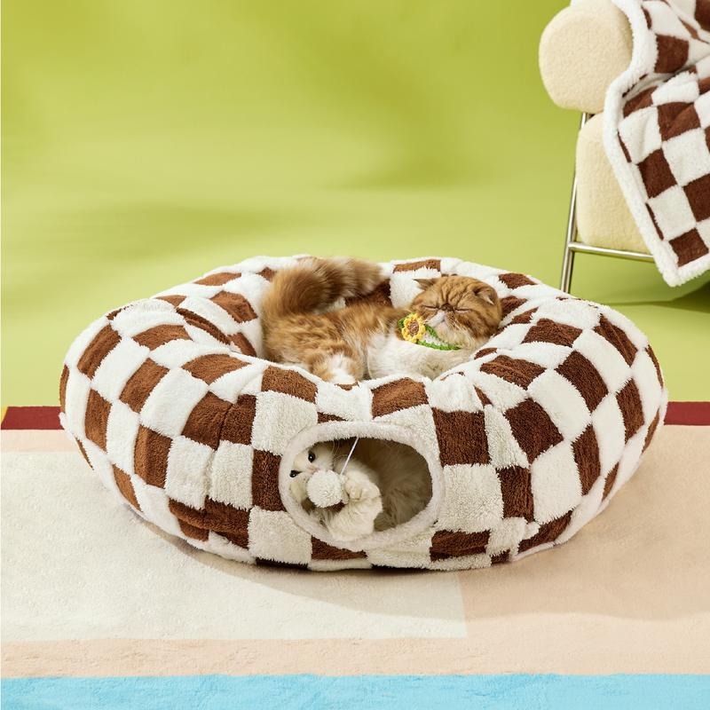 Cat lying in a brown and white checkered pet bed on a green chair.